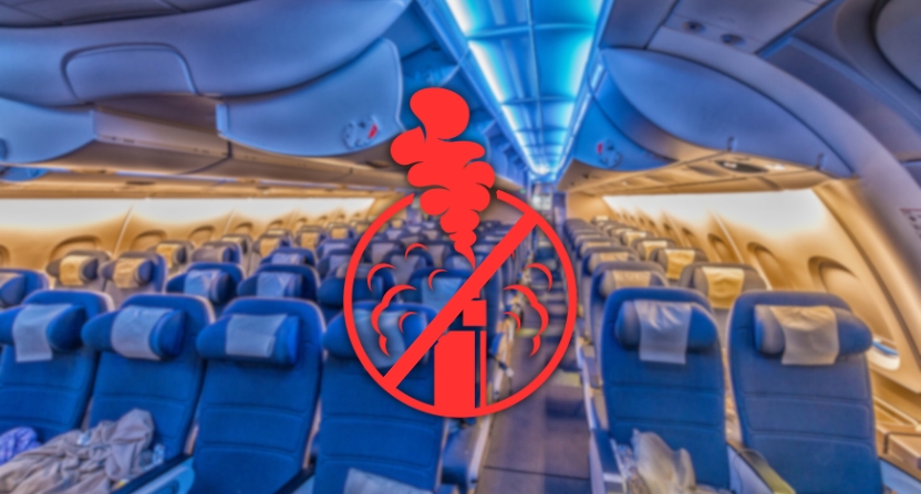 Cabine d'un avion avec des sièges vides et un symbole interdiction de vapoter au premier plan